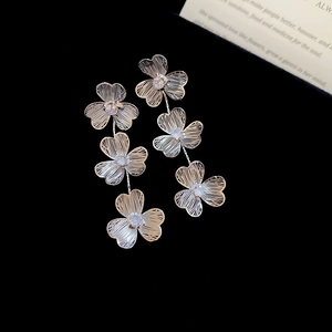 Vue détaillée de boucles d'oreilles fleurs en argent avec texture brossée et zircons