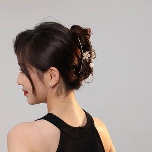Elegant gold metal flower hair claw clip with pearl pendant shown on hair from back view