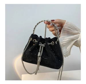 Detail of black rhinestone bucket bag with silver metal ring handle and chain strap