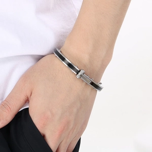 Close-up of minimalist stainless steel bracelet with black inlay on a male wrist