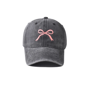 Dettaglio del ricamo a fiocco rosa su cappellino da baseball in cotone lavato antracite