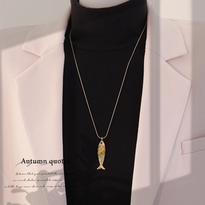 Detail of a vintage 3D koi fish pendant with green enamel on a golden chain necklace
