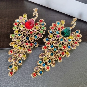 Detailed macro of peacock brooches with vintage gold finish and multi-color rhinestones