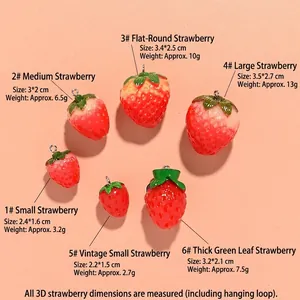 Various sizes of 3D resin strawberry charms displayed on a warm background for DIY crafts