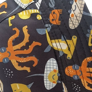 Gros plan du tissu d'un chapeau enfant avec motifs poulpes oranges et requins-marteaux