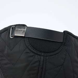 Detail of black quilted winter hat with adjustable leather strap and metal buckle