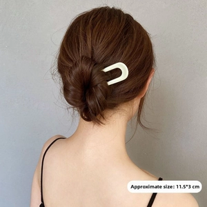 U-shaped hair pin in cream white showing 11.5x3cm dimensions on dark brown hair
