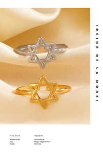Close-up of gold and silver hollow star rings on elegant champagne satin fabric background
