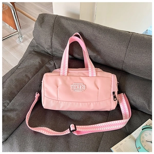 Pink dance sports bag with striped straps on sofa detail showing fabric and embroidery