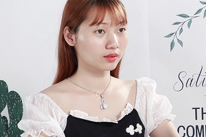 Detailed view of a silver swan pendant necklace with clear crystals on a model