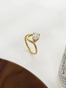Detail of 18K gold-plated titanium ring featuring a pear-cut zircon and fluid curved band