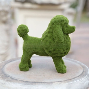 Detail of green flocked puppy statue with realistic moss texture on a stone pedestal