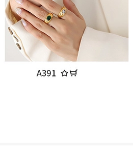 Close-up of gold rings with green oval gemstone and hammered band with white diamond