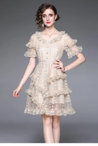 Detail of champagne lace dress with heavy floral embroidery and tiered ruffle hem