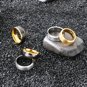 Polished and frosted tungsten steel rings in gold, silver, and black on a stone background