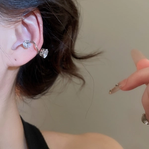 Detail view of silver ear cuffs with twisted metal bands and round zircon stones