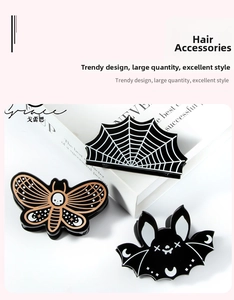Detailed view of Halloween hair claws featuring spider web, skull, and bat motifs