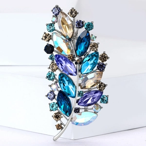 Detailed macro view of feather brooch with multi-colored crystals and silver plating