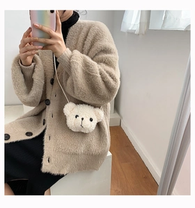 Mirror selfie showing the fluffy cream-colored bear plush crossbody bag on an outfit