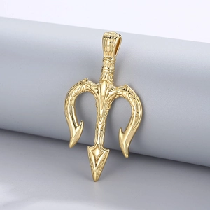 Gros plan du pendentif trident doré avec gravures détaillées sur socle gris