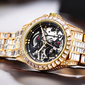 Macro shot of luxury gold watch dial with hollow movement and iced out baguette crystals
