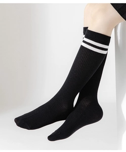 Close-up of black mesh sport calf socks with white double stripes on a model's leg