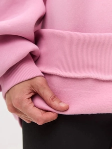 Close-up of pink sweatshirt showing the soft warm fleece lining and fabric texture