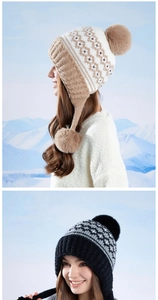 Close-up of Fair Isle knit hat with plush ear flaps and soft faux fur pom-poms