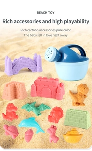 Close-up of 14-piece beach toy set with colorful animal molds and watering can on sand
