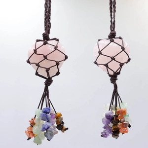 Detail of natural rose quartz heart pendant with handmade brown woven rope and stone tassels