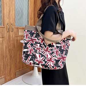 Detail of canvas tote bag featuring union jack print and wide brown woven shoulder straps