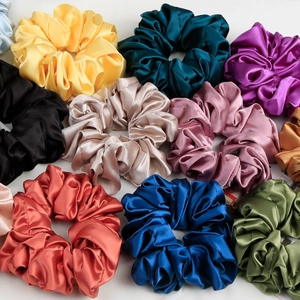 Close-up of assorted colorful satin scrunchies with pleated texture and soft silk finish
