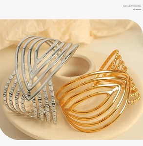 Detail view of multi-layer gold and silver plated stainless steel open bangles on stone