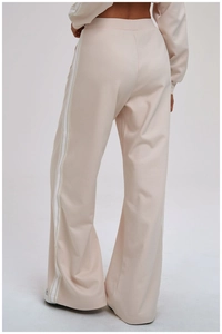 Detailed back view of beige wide-leg joggers featuring classic white side stripes