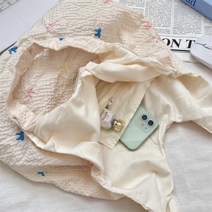 Détail de l'intérieur du sac brodé avec poche zippée et compartiment principal spacieux