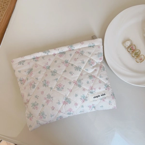 Detail of floral quilted cotton makeup bag with 'simple wish' label and floral clips