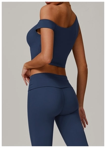 Vue détaillée du haut de yoga asymétrique bleu marine et du legging taille haute de profil