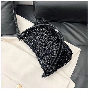 Macro shot of shimmering black sequins and leather handle on this stylish baguette bag