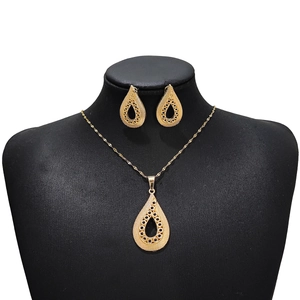Detail of vintage gold-tone necklace and teardrop earrings set with black gemstone accents