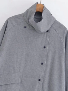 Close-up of black and white plaid shirt with unique high collar and side button closure