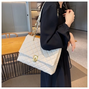 Close-up of beige quilted PU leather shoulder bag featuring golden metal twist lock and chain