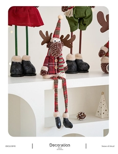 Detail of plush Christmas reindeer ornament with red plaid shirt and festive green scarf