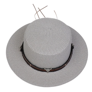 Detail of grey wide brim straw hat featuring a metal bull head and rivet decoration