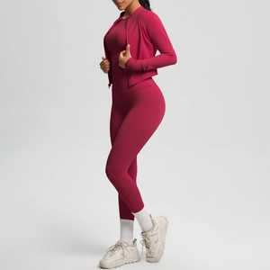 Detailed side view of women's three-piece burgundy yoga set with slim-fit gym leggings