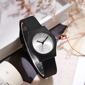 Macro detail of quartz watch with black silicone strap and sunray silver dial on white tray