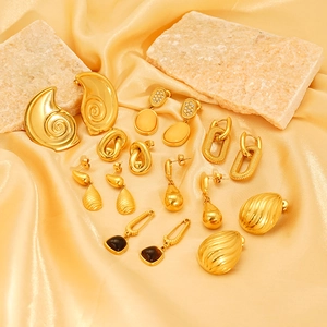 Détail de boucles d'oreilles goutte plaquées or 18 carats et pendentifs sur soie jaune