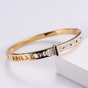 Detailed close-up of a gold-plated bracelet with Roman numerals and pavé set stones