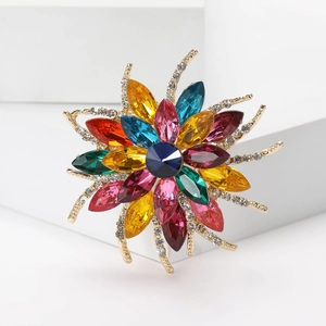 Macro shot of colorful rhinestone flower brooch with navy blue center and gold accents