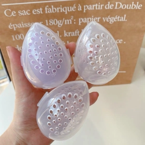 Drie heldere eivormige make-up spons cases met paarse spons en ventilatiegaten
