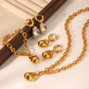 Détail d'un ensemble de bijoux dorés avec chaîne épaisse et pendentifs forme liquide